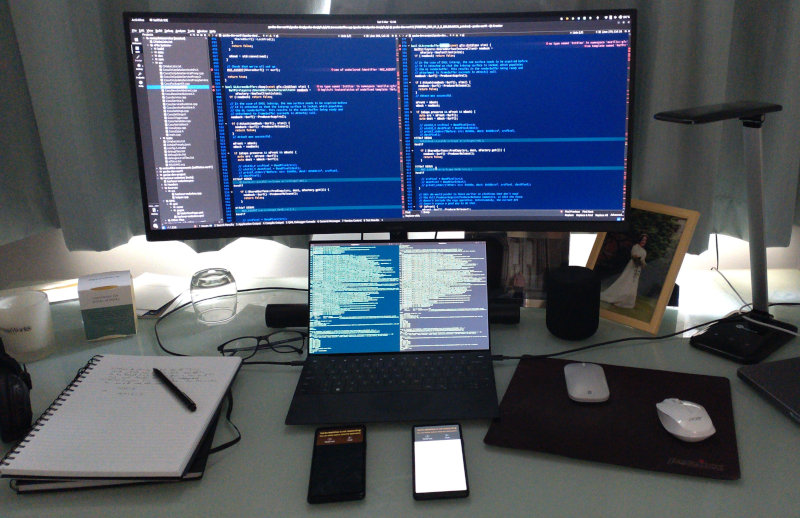 My desktop arrangement: laptop, two phones and a screen; plus some mess